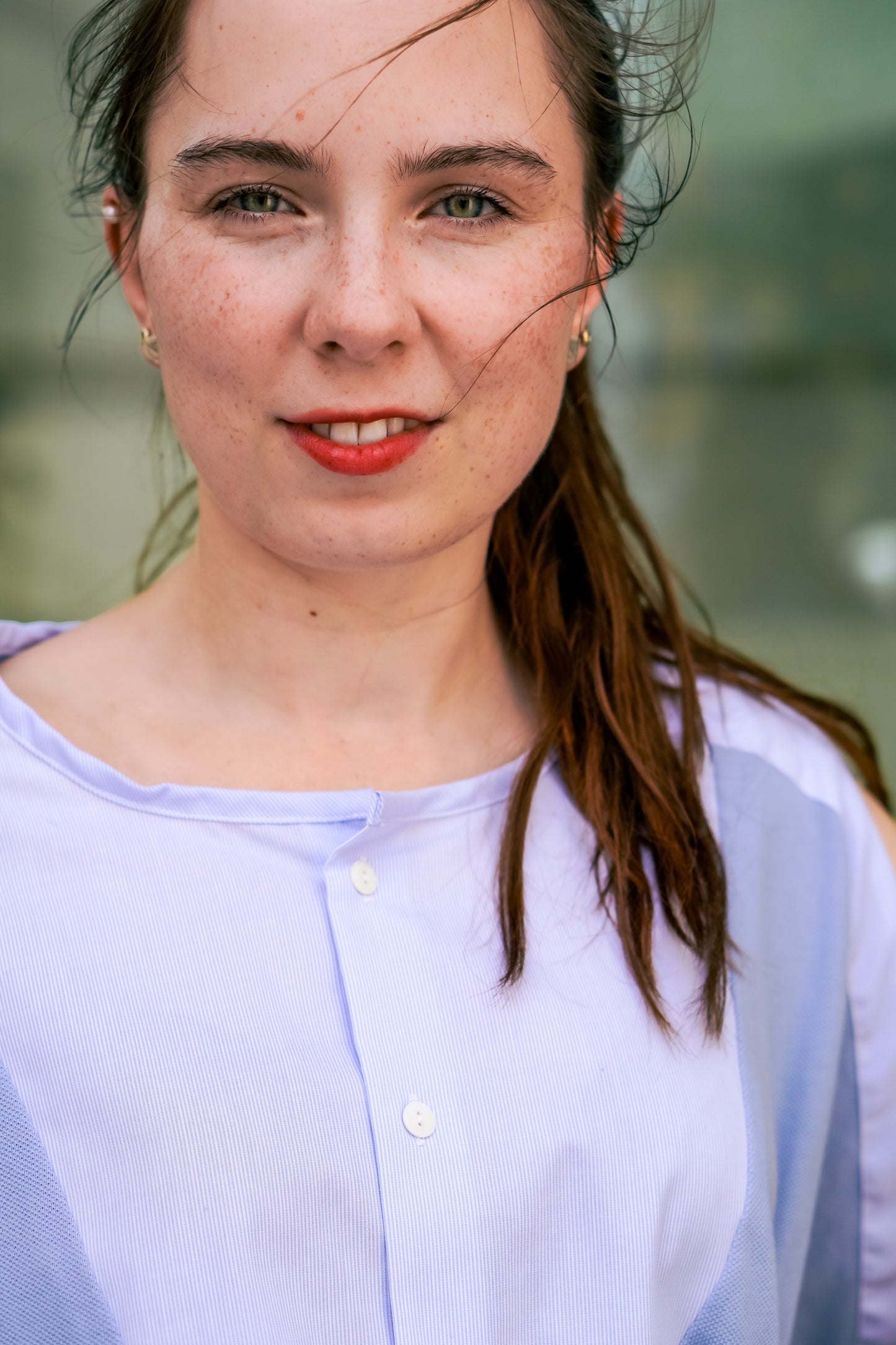 Frau in einer nachhaltigen hellblauen Bluse von LIMO zeigt Eleganz im Bereich Slow Fashion, ideal für nachhaltige Businessmode.