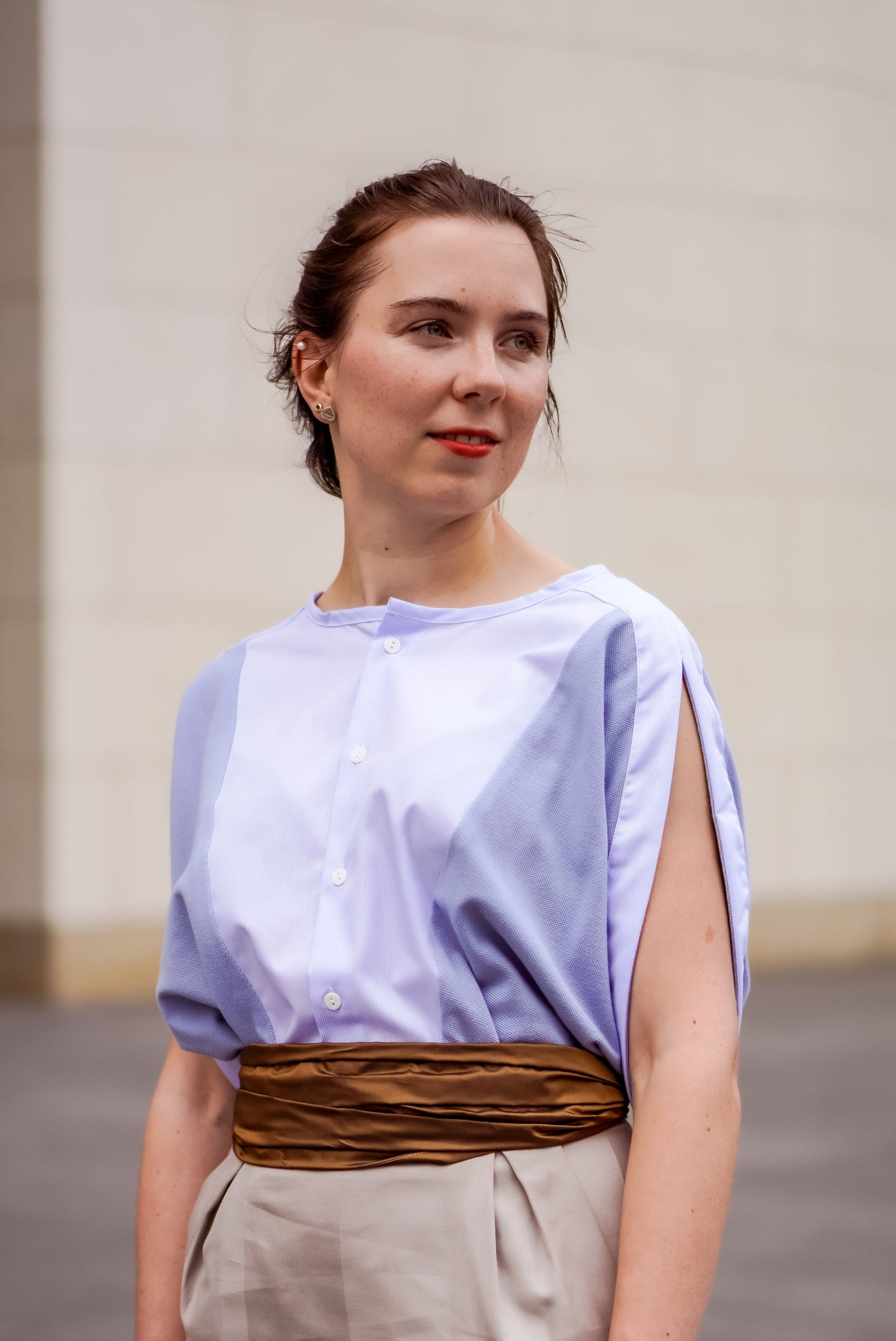 Elegante Frau in LIMO's hellblauer Bluse unterstreicht den Stil von Slow Fashion, ein Paradebeispiel für nachhaltige Büromode.