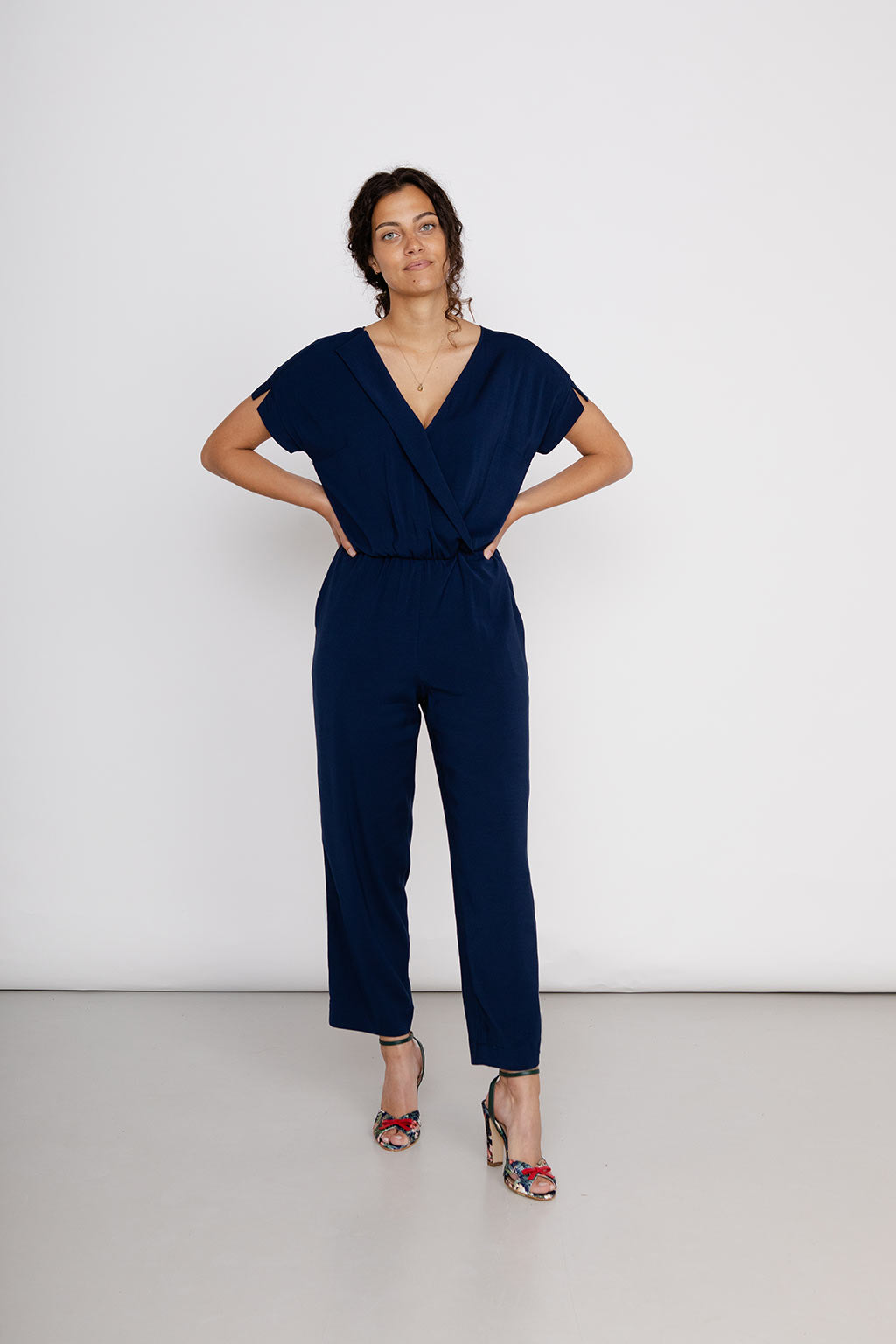 Slow Fashion trifft auf nachhaltigen Luxus: Vorgeransicht blaue Jumpsuit von NINA REIN mit schrägen Eingriffstaschen und verkürztem Bein, aus nachhaltiger Forstwirtschaft.